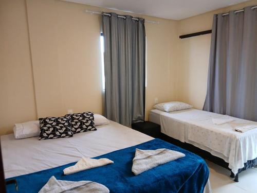 zwei Betten in einem Zimmer mit Handtüchern darauf in der Unterkunft Liszen flats in Porto De Galinhas