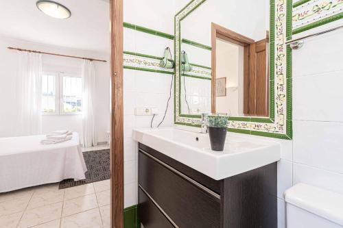 un bagno bianco con lavandino e specchio di Villa Pinya a El Tosalet