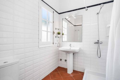 a white bathroom with a sink and a mirror at Villa Punta Rosa in Punta Prima