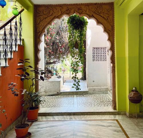 een toegang tot een gebouw met een boog en planten bij Hotel Paramount Palace in Pushkar