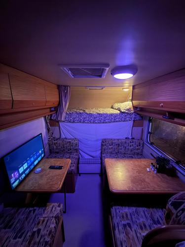 Een interieurfoto van een camper met een bed en tafels. bij Camper room bunde in Bunde