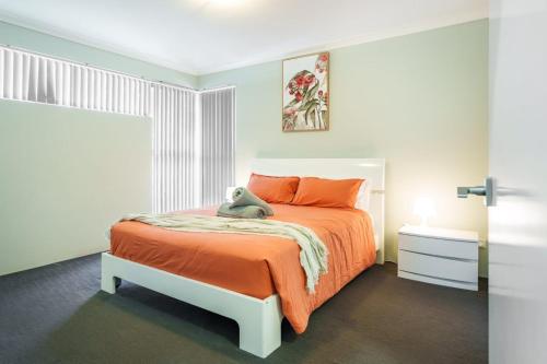 a bedroom with a bed with a teddy bear on it at Queens Residence Perth Western Australia in Perth