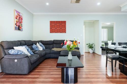 a living room with a couch and a table at Queens Residence Perth Western Australia in Perth