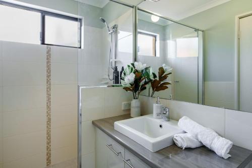 a bathroom with a sink and a mirror at Queens Residence Perth Western Australia in Perth