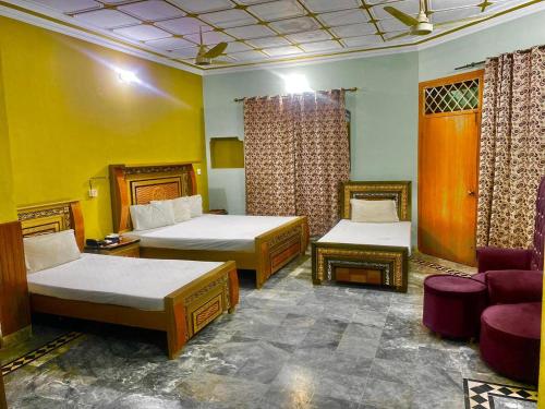 a hotel room with two beds and a couch at Hotel Royal Luxury Multan in Multan