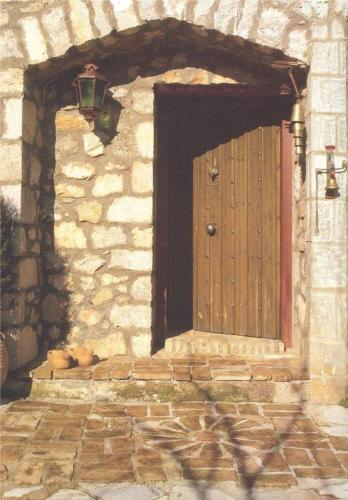 a wooden door in a stone building with a lamp at 260m2 Unique mountain house in Lilea Parnasos in Lílaia
