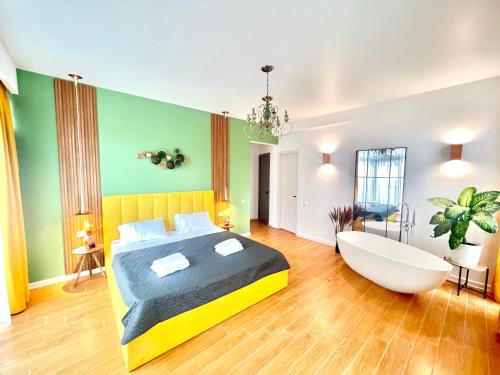 een slaapkamer met een groot bed en een bad bij Mohika Boutique Aparthotel in Tbilisi City