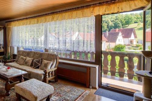 a living room with a couch and a large window at Ferienwohnung in Lichtenfels mit 125 Quadratmeter in Lichtenfels
