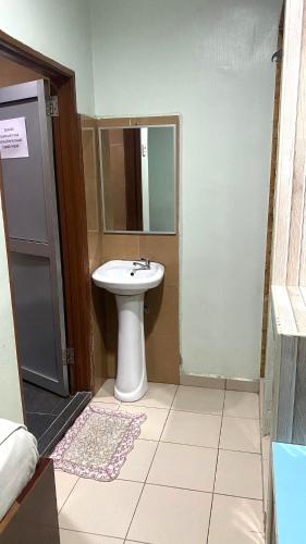 a bathroom with a sink and a mirror at Capital O 91275 Pr Motel in Changlun