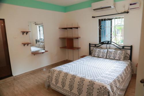 a bedroom with a bed in a room with a window at Dreamcatcher House & Hostel at Arambol Beach in Arambol