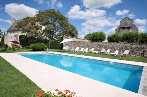een zwembad voor een stenen huis bij Gîtes du Château de Meux in Meux