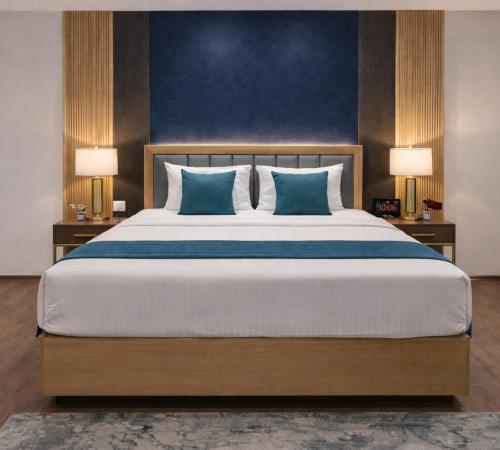 a bedroom with a large bed with blue walls at Kriya Grandeur Hotel in Secunderabad