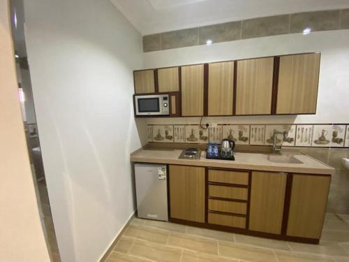 a small kitchen with a sink and a microwave at فرويال للشقق المخدومة in Nughaylah