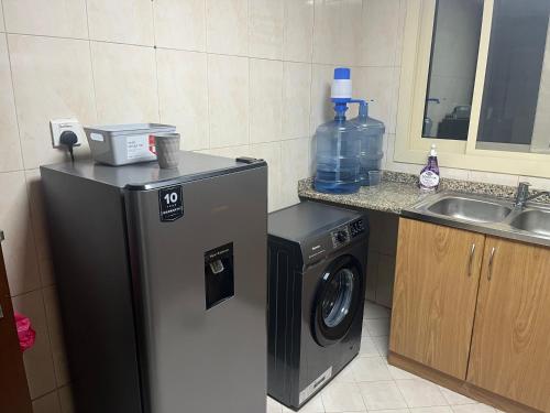 a kitchen with a washing machine and a sink at comfort private master room in Sharjah