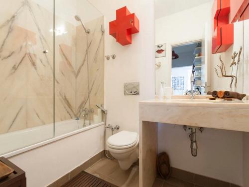 a bathroom with a toilet and a shower and a sink at Pátio Alfama in Lisbon