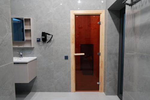 a bathroom with a red door and a sink at AURA camping in Zhezdi