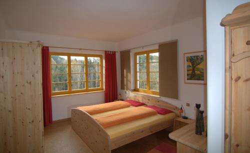 a bedroom with a bed and two windows at Villa Weißig in Struppen