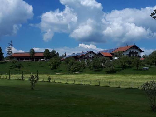 a house on top of a green field with a house at Schwaigerhof in Wackersberg