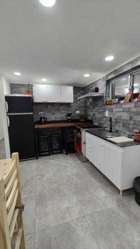 een keuken met witte kasten en een aanrechtblad bij Depto Roko in Villa Gesell