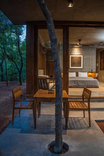 a bedroom with a table and two chairs and a tree at VeeRaa Retreat in Habarana