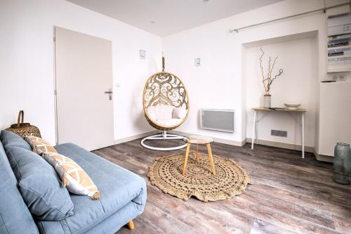 a living room with a blue couch and a table at les doux secrets de Bergère in Périgueux
