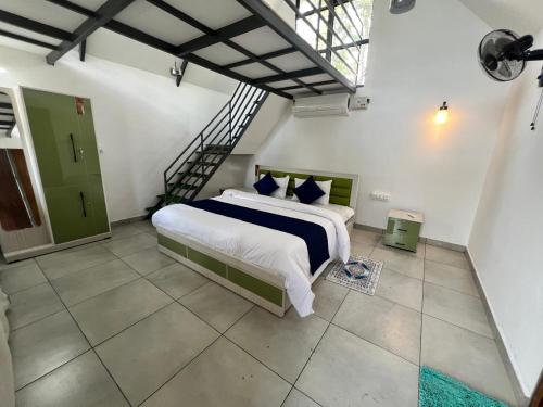 une chambre avec un grand lit et un escalier dans l'établissement Nefs Dreams Villa, à Vaduvanchal