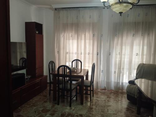 ein Esszimmer mit einem Tisch und Stühlen sowie ein Schlafzimmer in der Unterkunft El Lucentino in Lucena