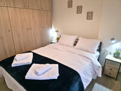 a bedroom with a large white bed with towels on it at 2Steps to the Lake in Kastoria