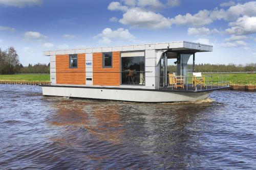 a house boat in the water on a river at Hausboot und Zimmervermietung Boot & Bike Hansestadt Anklam in Anklam