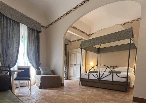 una camera con letto a baldacchino e sedia di Hotel Villa San Lucchese a Poggibonsi