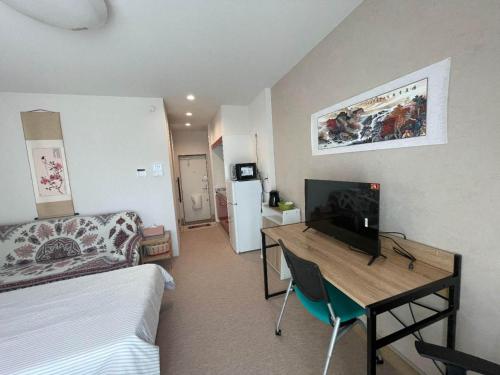 a room with a bed and a desk with a television at 北滨Grace DAY 101 in Takamatsu