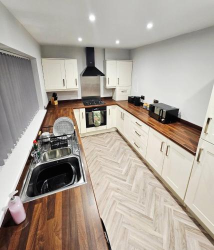 a kitchen with white cabinets and a sink at Sea View House Marske-by-the-Sea - Coastal Stay - Pet Friendly in Marske-by-the-Sea