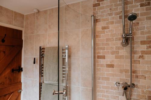 a shower with a glass door in a bathroom at River Cottage in Beccles
