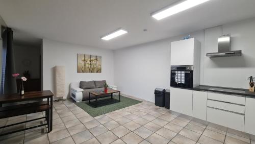 a kitchen and living room with a couch and a table at Gästehaus Ferienwohnung Wohnung #3 in Jülich
