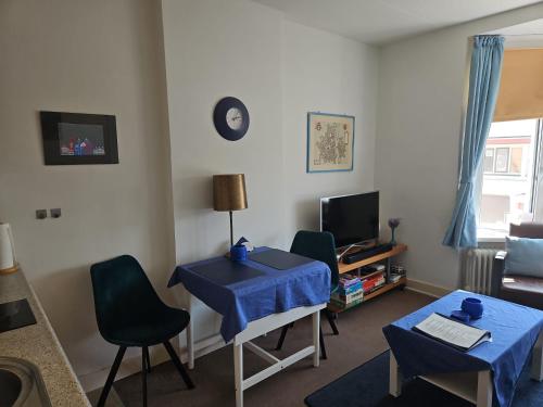 a living room with a blue table and chairs at BnB Sharon's and Ser's place in Heer-Maastricht in Maastricht