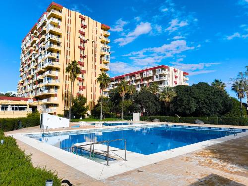 ein Schwimmbad vor einem hohen Gebäude in der Unterkunft B&F Paloma in Benalmádena