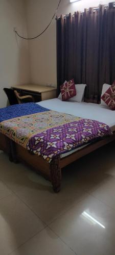 a bedroom with two beds with a comforter on it at Apartment Home Stay in Bangalore