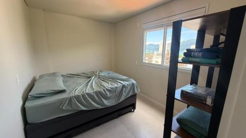 a bedroom with a bunk bed and a window at Cód 2 - Cobertura de 2 dormitórios na Praia Grande in Rodeio