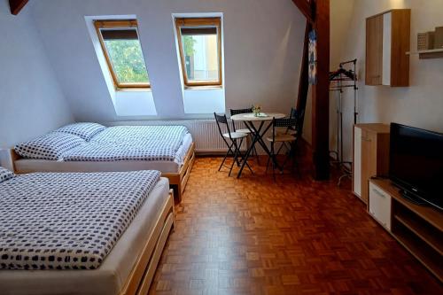 een kamer met 2 bedden, een tafel en een televisie bij Ubytování na Křížovce in Chlum u Třeboně
