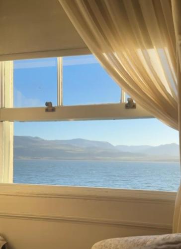 a bedroom window with a view of the ocean at The Suites At Ty Anne in Beaumaris