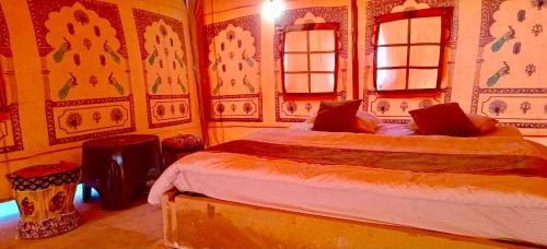 een slaapkamer met twee bedden en twee ramen bij K R Desert Resort in Dedha