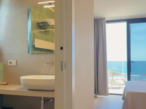 ein Badezimmer mit einem Waschbecken auf einer Theke neben einem Fenster in der Unterkunft Hotel Continental in San Benedetto del Tronto