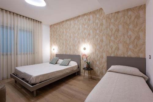 a bedroom with two beds and a wall at Residence Perla in Misano Adriatico