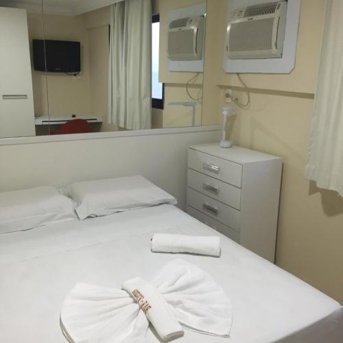 a bedroom with a white bed with a mirror at Apartamento Boa Viagem in Recife