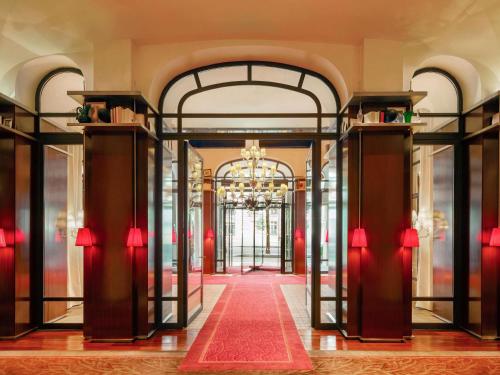 een lobby met een rode loper en een kroonluchter bij Hôtel Le Royal Monceau Raffles Paris in Parijs