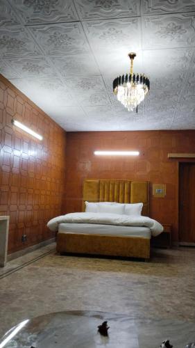 a bedroom with a large bed with a chandelier at Hotel living spot in Lahore