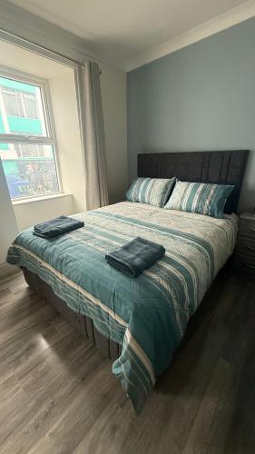 a bedroom with a bed with two towels on it at Tipperary Town House in Tipperary