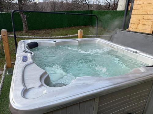 a hot tub with water in it in a backyard at A-Frame Wellness Villa with Private Pool, Sauna & Jacuzzi near Belgrade in Koraćica