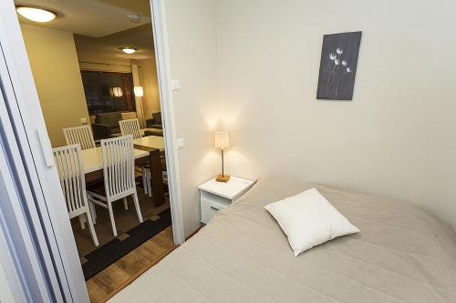 a bedroom with a bed and a table and chairs at Cozy Alpine-Style Apartment in the Heart of Levi with Private Sauna & Fireplace in Levi