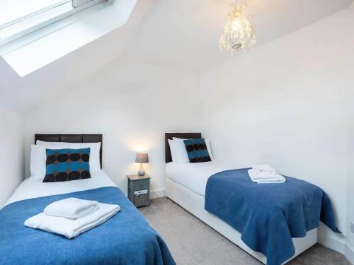 2 letti in una camera bianca con lenzuola blu di Riverside House a Lundin Links